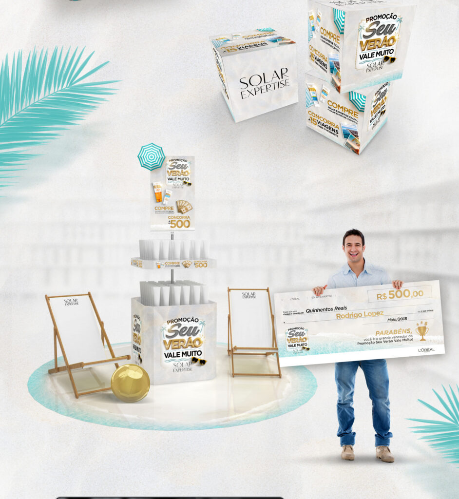 Display de chão com temática de praia, cubos promocionais empilhados e homem segurando cheque festivo de premiação L'Oréal
